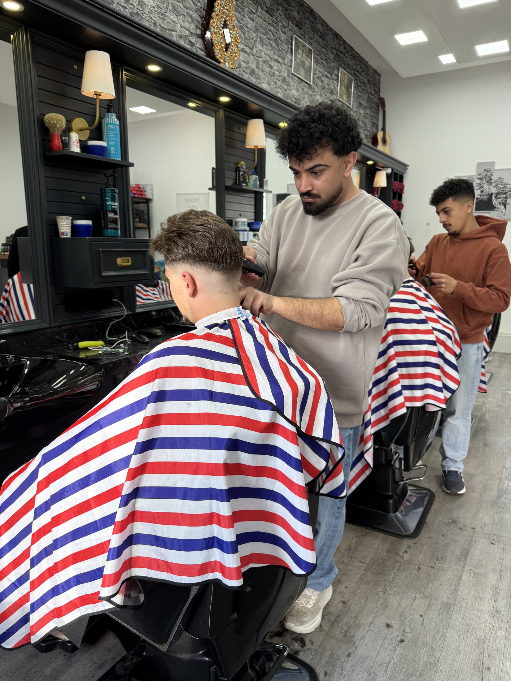 Barber beim präzisen Haarschnitt im Barber Shop Leonding