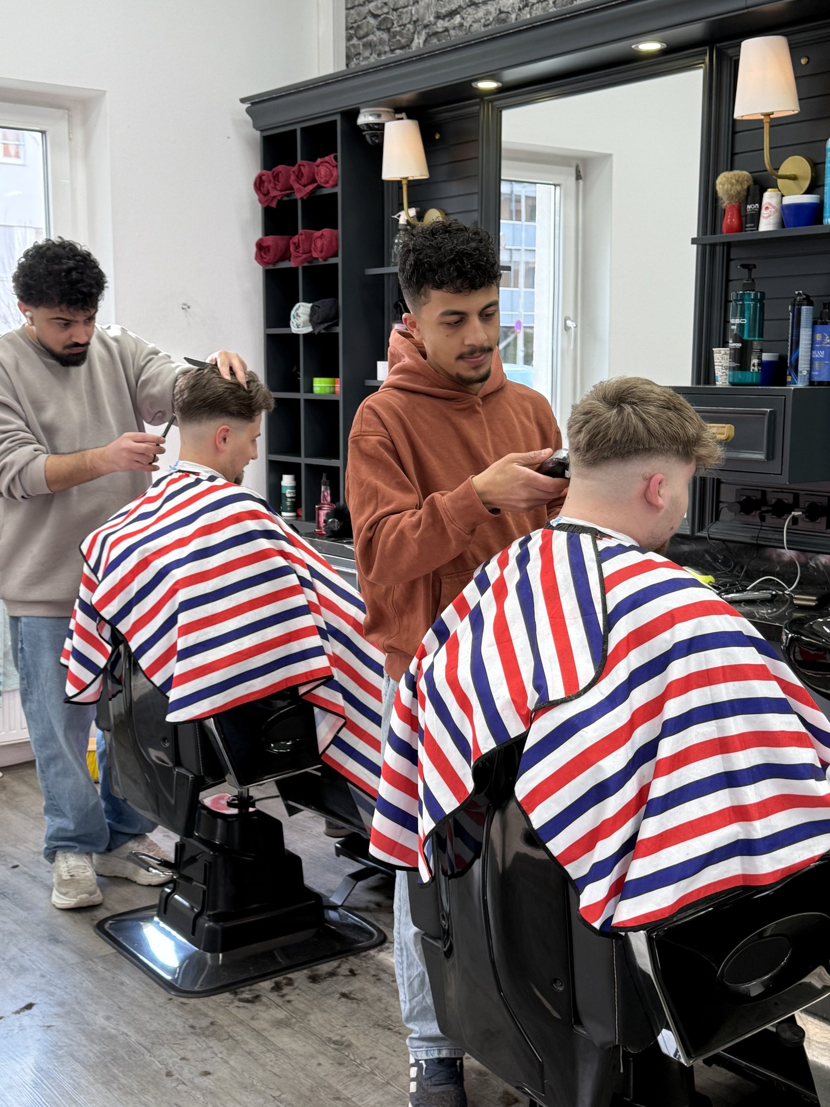 Mehrere Barber bei Haarschnitten