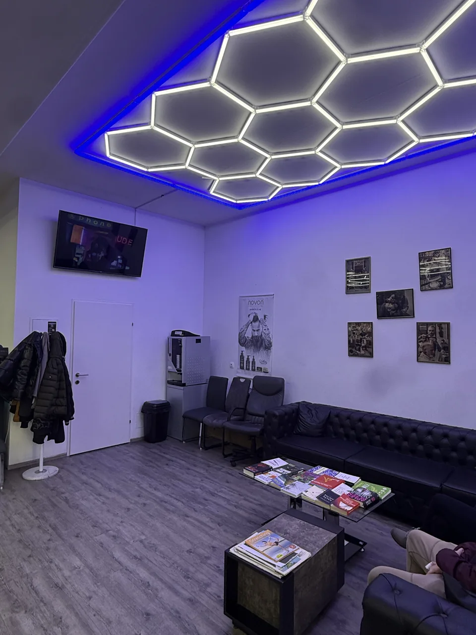 Loungebereich mit dunklem Sofa und geometrischer Beleuchtung
